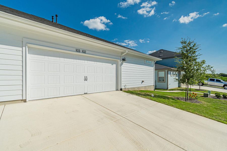 A pristine driveway leads to a classic garage, offering ample parking and seamless home access. A pristine driveway leads to a classic garage, offering ample parking and seamless home access.