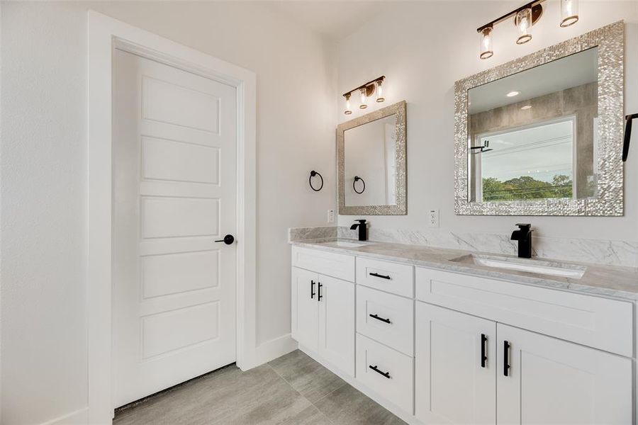 Bathroom with double vanity and baseboards