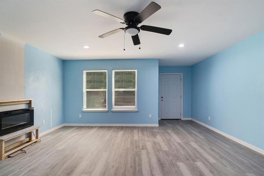 Unfurnished living room with wood finished floors, recessed lighting, and a ceiling fan Unfurnished living room with wood finished floors, recessed lighting, and a ceiling fan