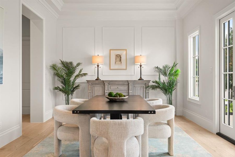 Dining area featuring ornamental molding and light wood-type flooring Dining area featuring ornamental molding and light wood-type flooring