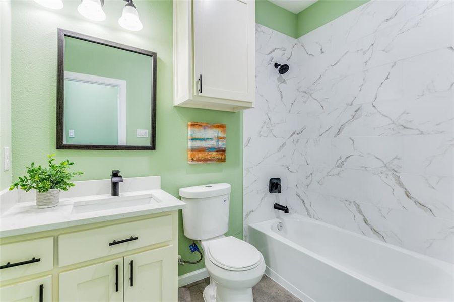 Full bathroom featuring vanity, tiled shower / bath, tile patterned floors, and toilet