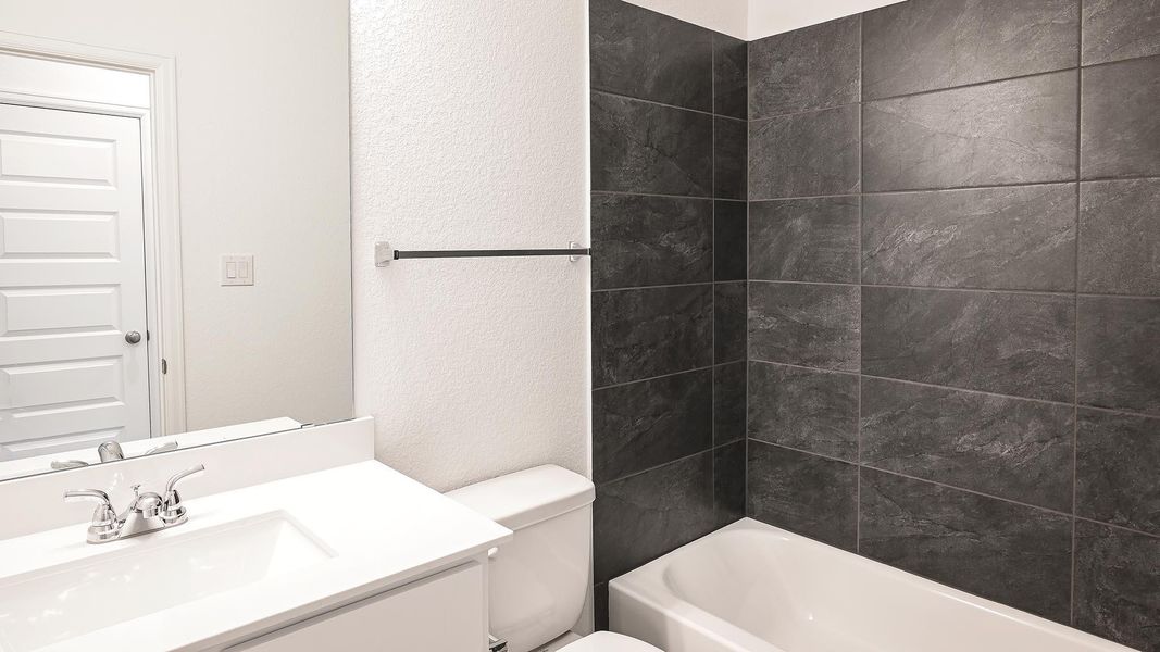 Bathroom with a textured wall, vanity, and shower combination Bathroom with a textured wall, vanity, and shower combination