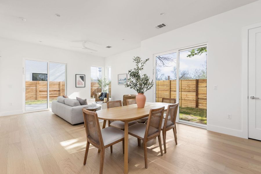 Dining area featuring light wood finished floors, healthy amount of natural light, and ceiling fan Dining area featuring light wood finished floors, healthy amount of natural light, and ceiling fan
