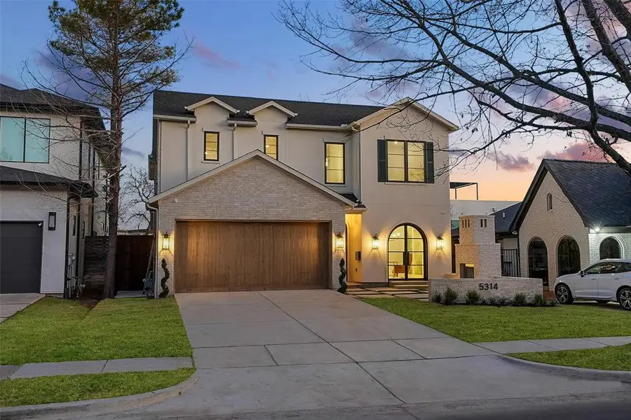 View of front of property featuring stucco siding, concrete driveway, a front lawn, and french doors View of front of property featuring stucco siding, concrete driveway, a front lawn, and french doors