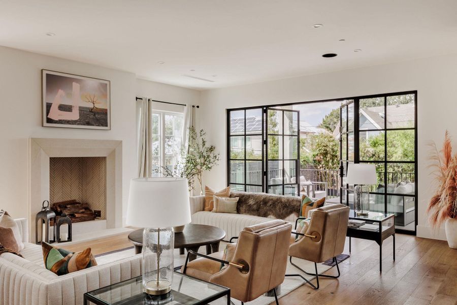 Walls of glass bathe the living room in natural light, highlighting the sleek fireplace and curated finishes that define the home’s refined aesthetic. Walls of glass bathe the living room in natural light, highlighting the sleek fireplace and curated finishes that define the home’s refined aesthetic.