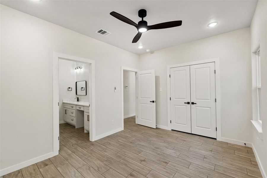 Light wood-finish flooring with recessed lighting and a ceiling fan Light wood-finish flooring with recessed lighting and a ceiling fan