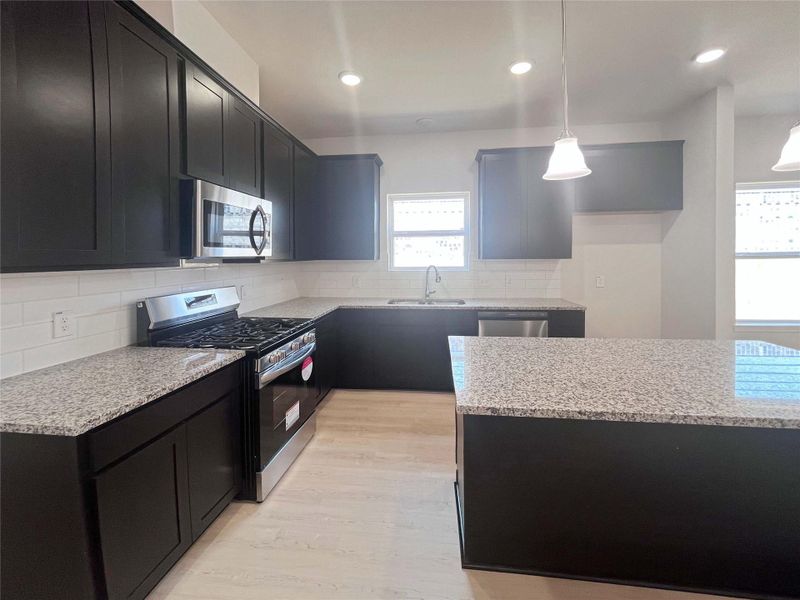 Kitchen with Island. Home under construction. Sample floor plan photo used for illustrative purposes only. Upgrades, selections options, windows and colors may vary.