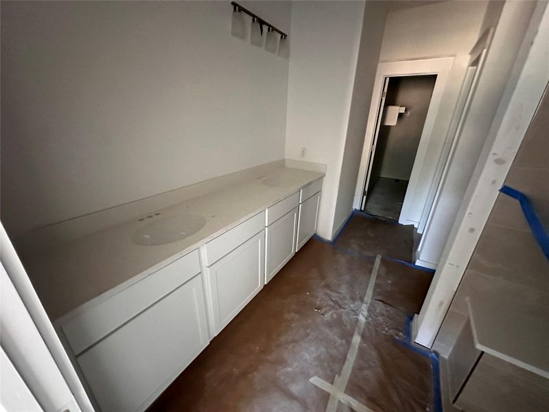 Corridor featuring unfinished concrete floors and a sink Corridor featuring unfinished concrete floors and a sink