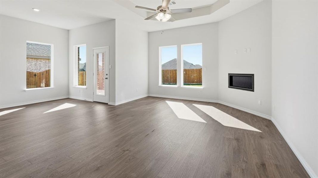 The property features a spacious room with light gray walls, wood-look flooring, and a ceiling fan The property features a spacious room with light gray walls, wood-look flooring, and a ceiling fan