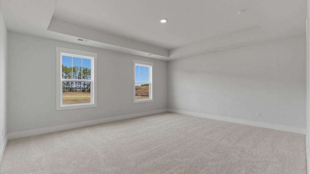 Elegant primary suite with tray ceiling and walk-in closet in this top-notch Foxbank single family home