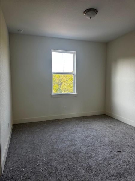 Spare room with dark colored carpet and baseboards Spare room with dark colored carpet and baseboards