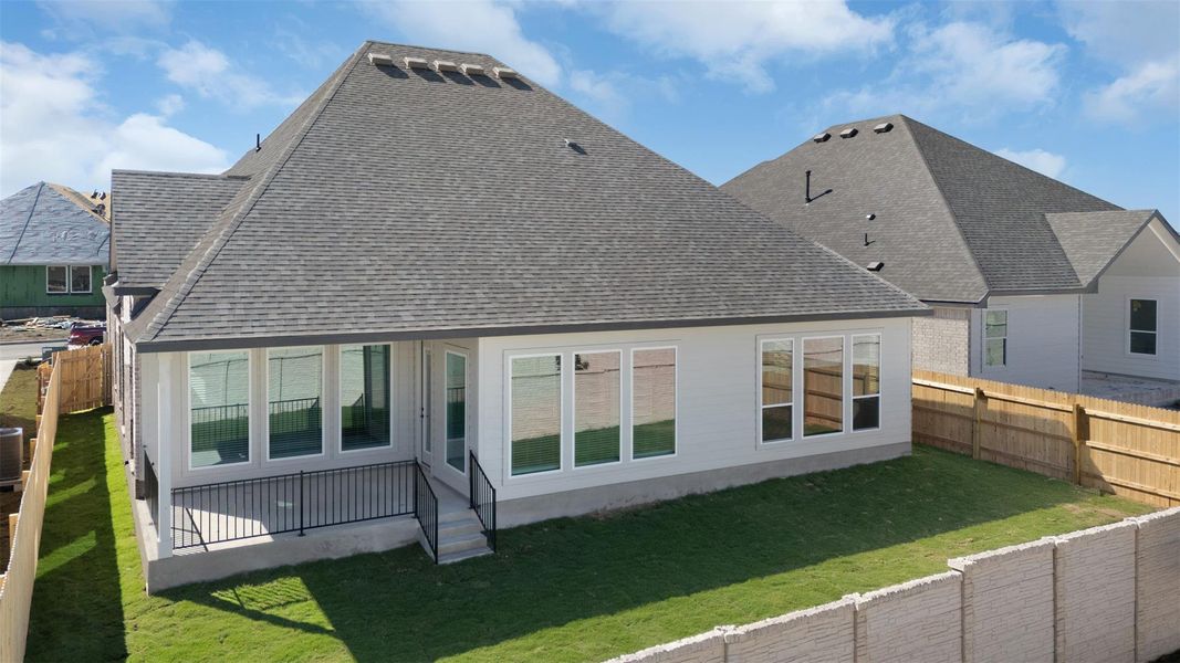 Back of house with roof with shingles, a fenced backyard, and a patio area