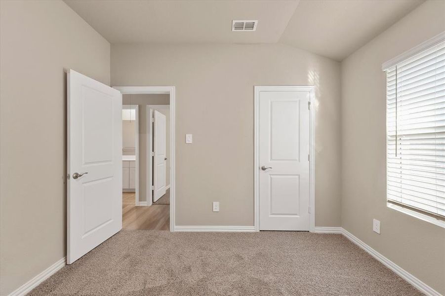 Unfurnished bedroom with light colored carpet and baseboards Unfurnished bedroom with light colored carpet and baseboards