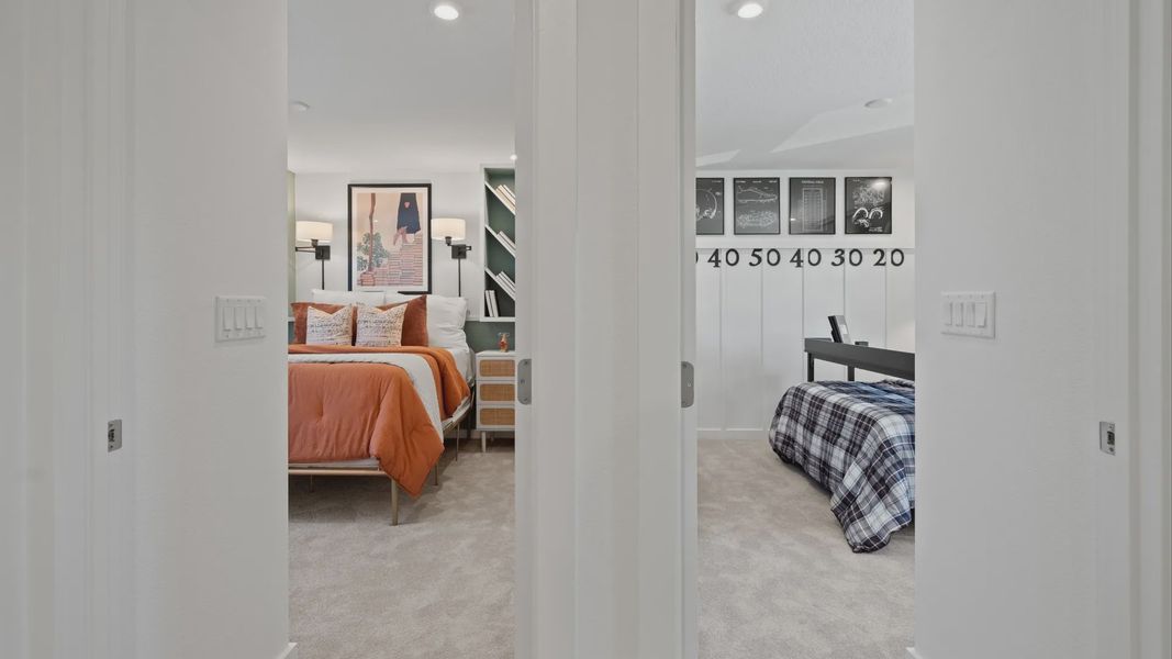 Carpeted secondary bedrooms in a DRB Home Clementine model at the Trinity Place community.
