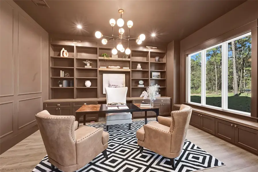 Home office featuring built-in cabinetry, custom lighting fixtures, and integrated window benches.
