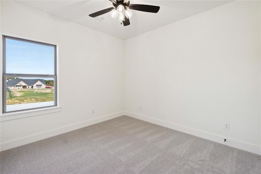 Unfurnished room featuring ceiling fan and light colored carpet