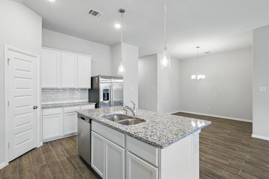 Kitchen featuring stainless steel appliances, dark wood-style floors, a kitchen island with sink, tasteful backsplash, and recessed lighting Kitchen featuring stainless steel appliances, dark wood-style floors, a kitchen island with sink, tasteful backsplash, and recessed lighting