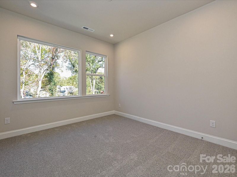 Secondary Bedroom With Large Windows Facing Mature Trees.
