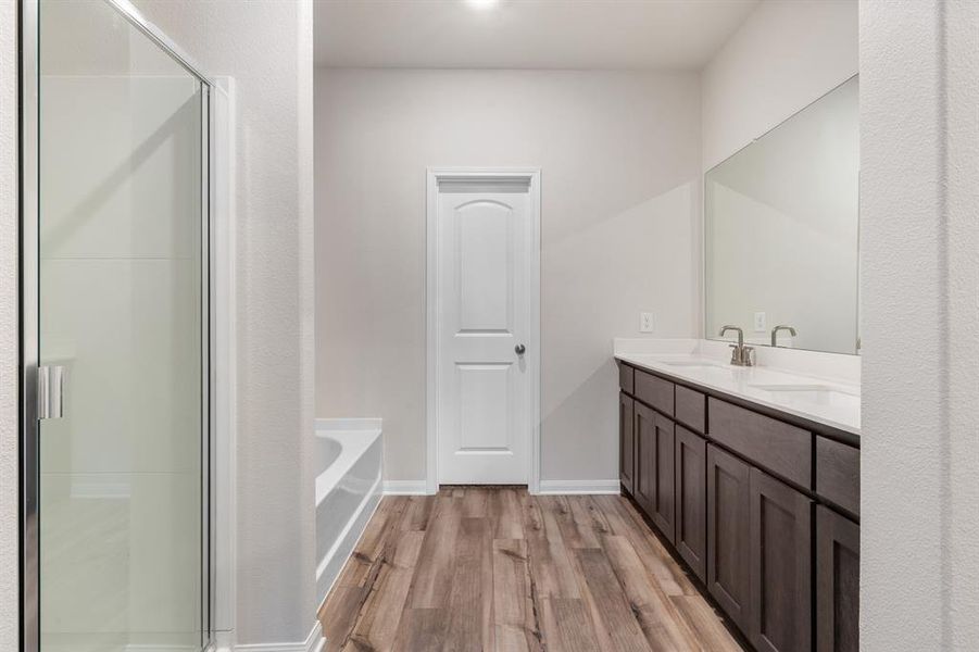 Bathroom featuring separate shower and tub, vanity, and hardwood / wood-style flooring