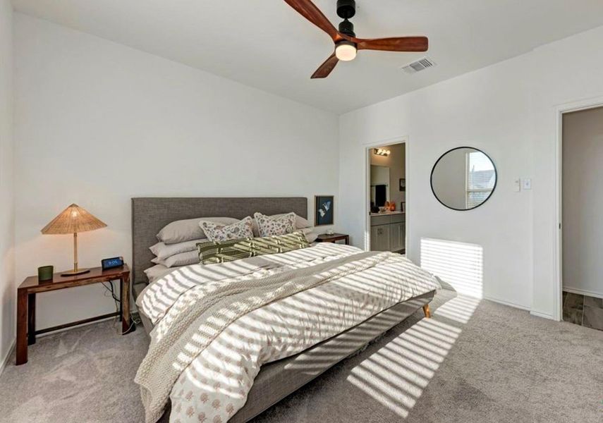 Bedroom featuring light colored carpet, connected bathroom, and ceiling fan Bedroom featuring light colored carpet, connected bathroom, and ceiling fan