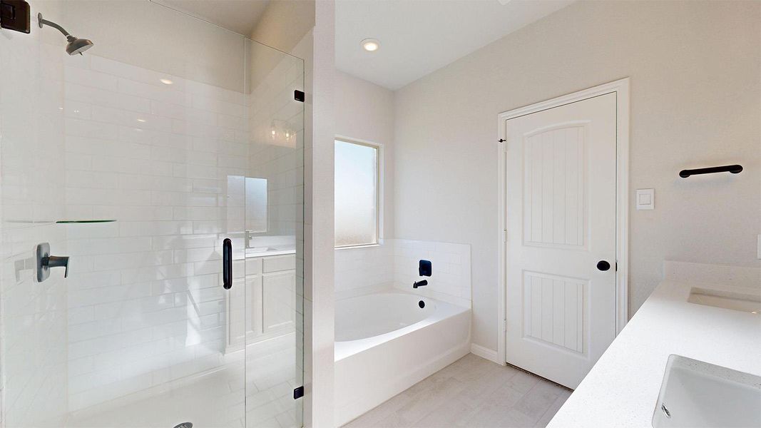 Bathroom featuring a stall shower, a bath, and double vanity