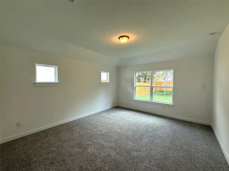 Carpeted spare room featuring baseboards Carpeted spare room featuring baseboards