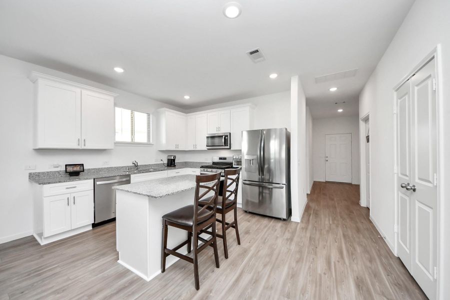 Greeted by open floor plan kitchen/dining/living area