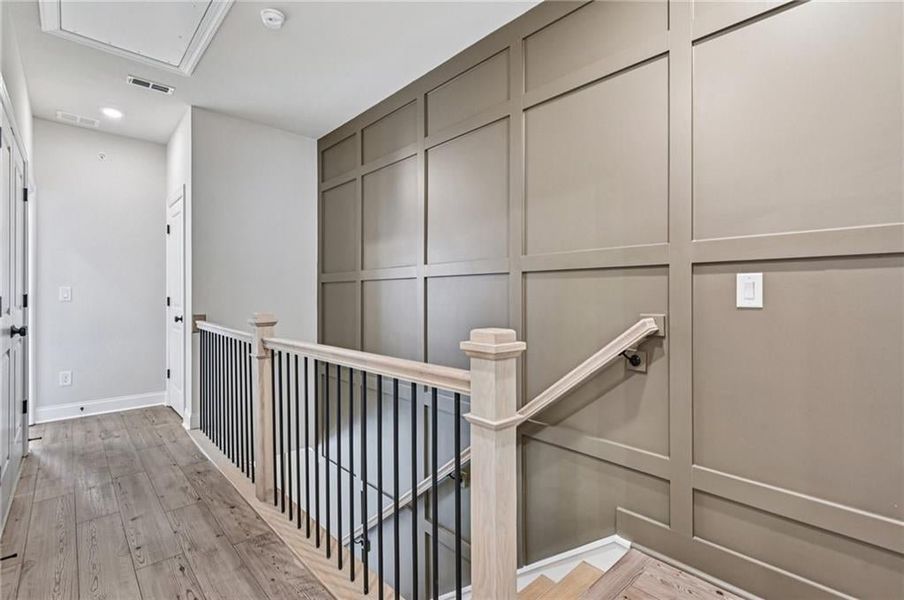 Corridor featuring an upstairs landing, light wood finished floors, and recessed lighting