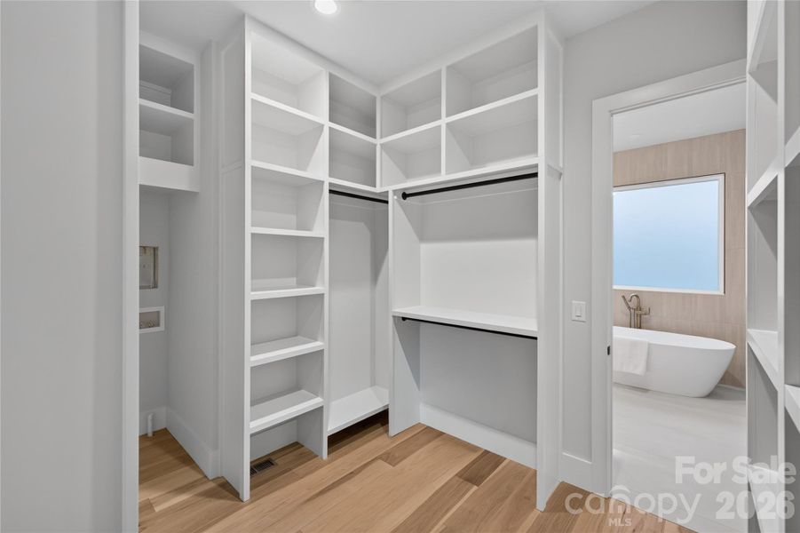 Custom shelving with Laundry connections in primary closet. Large full laundry upper level.