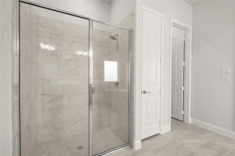 Full bathroom featuring a marble finish shower, baseboards, and marble finish floors Full bathroom featuring a marble finish shower, baseboards, and marble finish floors