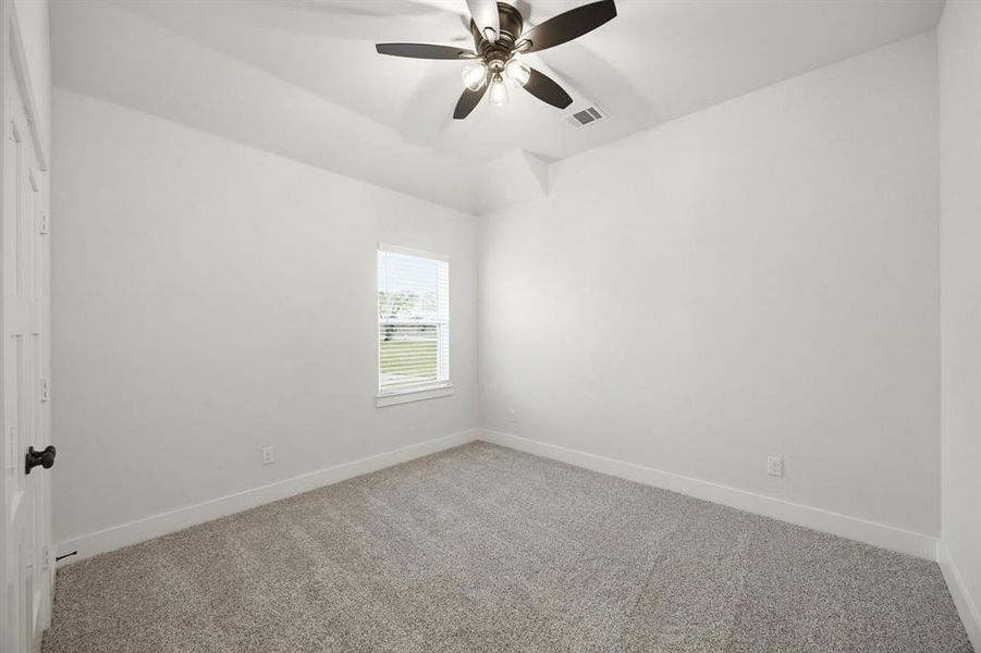 Spacious room with plush gray carpeting, crisp white walls, and a recessed window featuring horizontal blinds