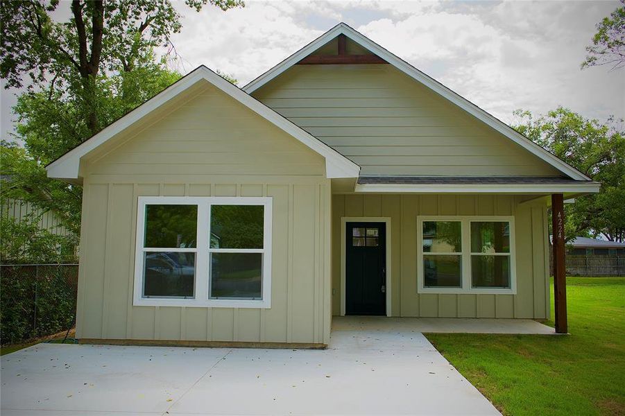 View of front of house with board and batten siding and a patio area