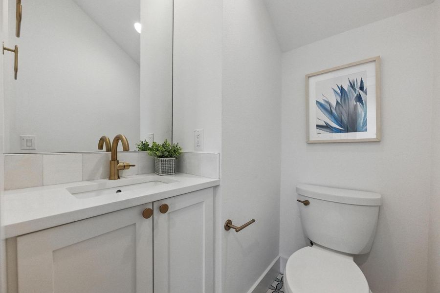 Half bathroom featuring vanity and toilet Half bathroom featuring vanity and toilet