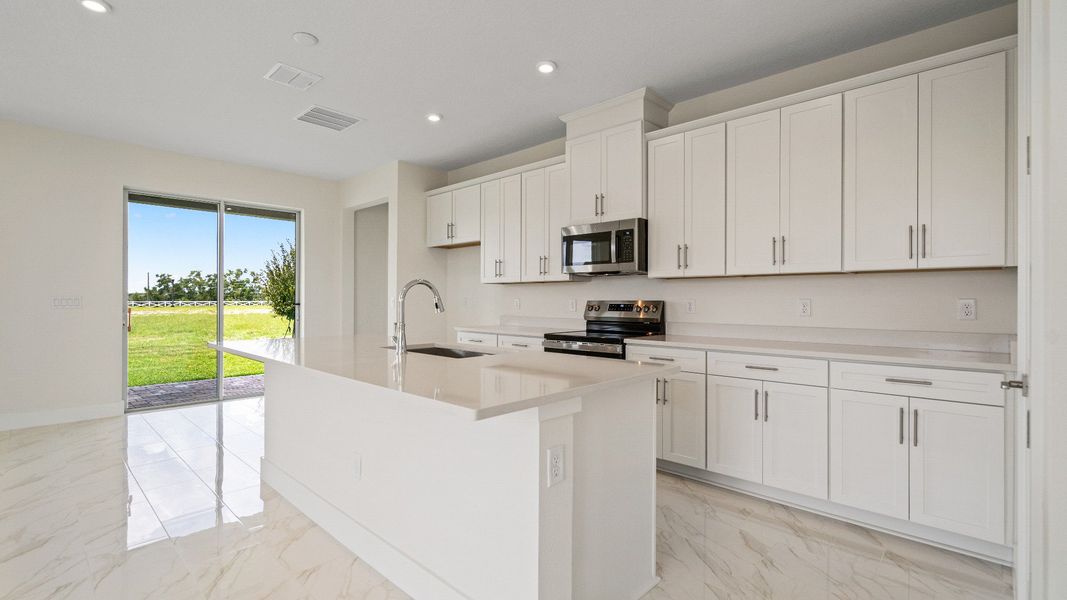 The Sweetgum Spacious and Bright Kitchen with large Island in two story home in Trailside in Mount Dora by DRB Homes