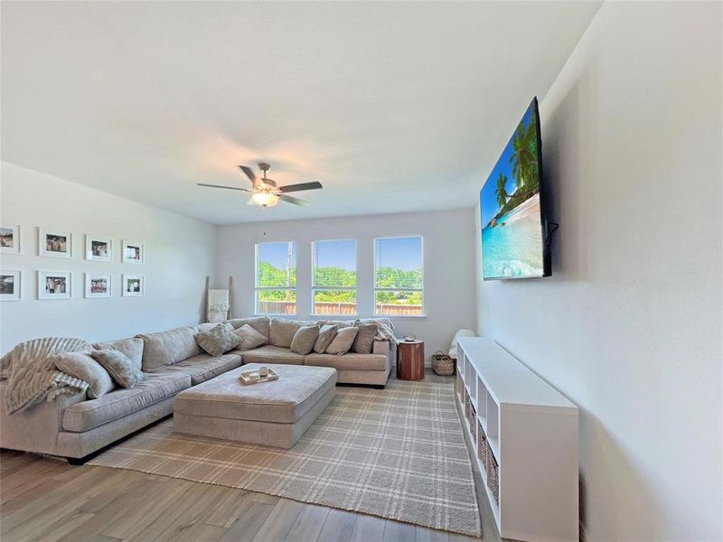 Living room with wood finished floors and a ceiling fan
