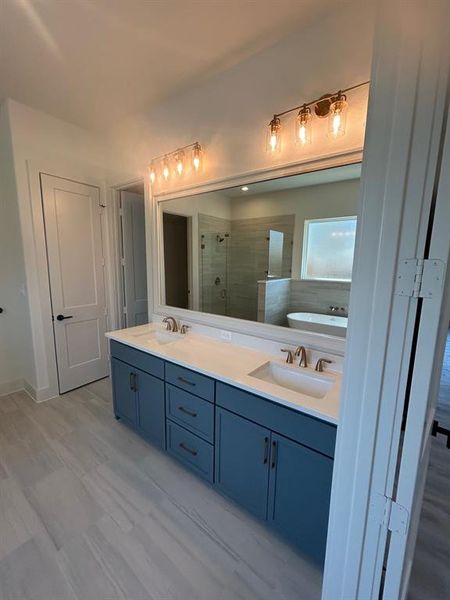 Primary bathroom with double vanity framed mirror, and linen closet