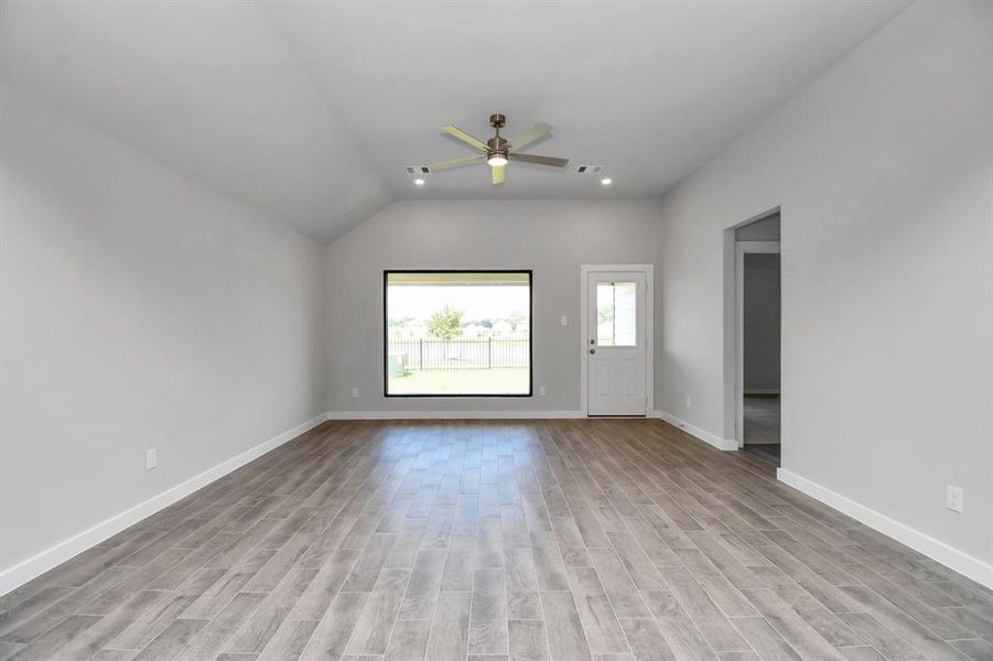 Enjoy the expansive space adorned with high ceilings, recessed lighting, a stylish ceiling fan, custom paint, exquisite flooring, and generously sized windows that fill the room with an abundance of natural light. Sample photo of completed home. As-built color and selections may vary.