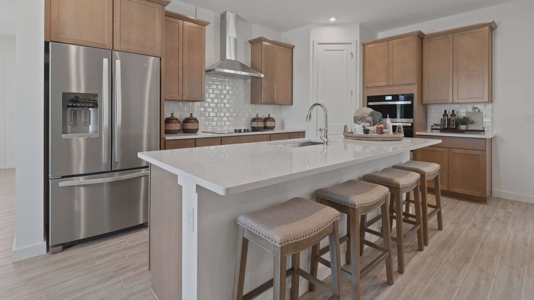 Kitchen with large island and and corner pantry in a DRB Home Clementine model at the Trinity Place community.