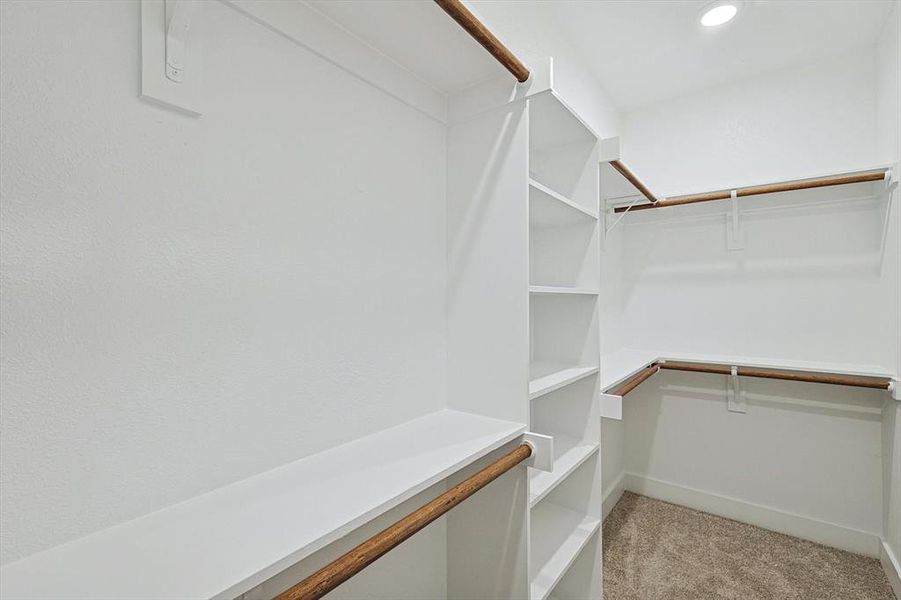 Walk in closet featuring light colored carpet