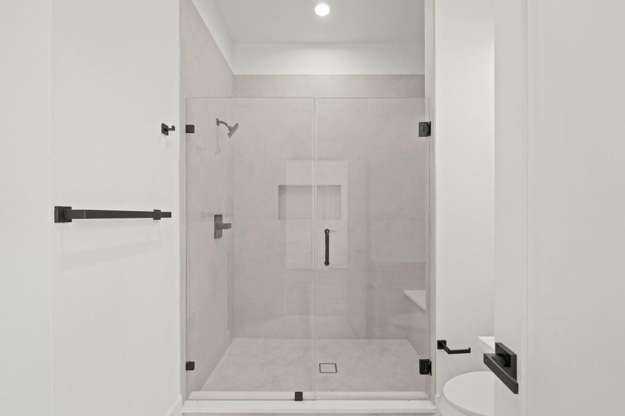 The oversized shower includes a tiled shower seat.