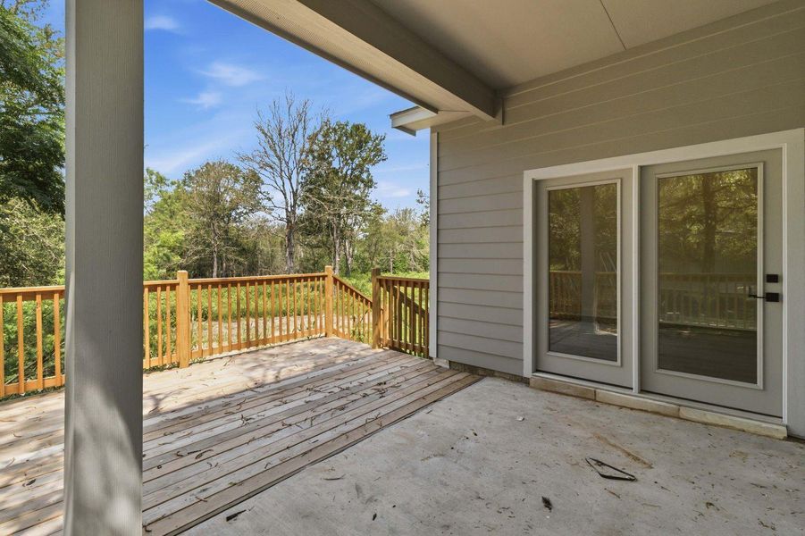 A spacious outdoor deck with wood railings offers a serene view of the surrounding trees. A spacious outdoor deck with wood railings offers a serene view of the surrounding trees.