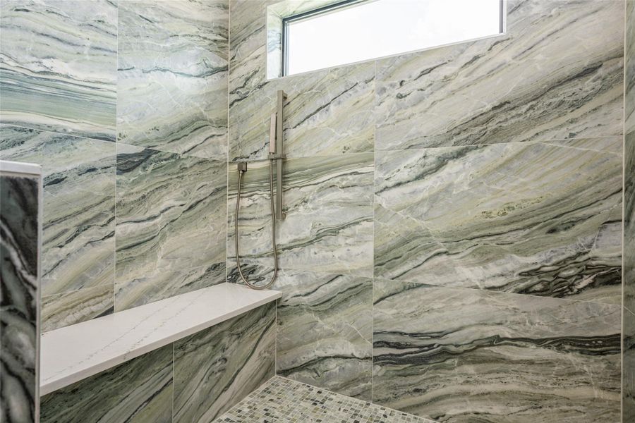 The shower suite boasts three heads—rainfall, wall-mounted, and handheld—surrounded by porcelain tile to the ceiling and framed by a bright window The shower suite boasts three heads—rainfall, wall-mounted, and handheld—surrounded by porcelain tile to the ceiling and framed by a bright window