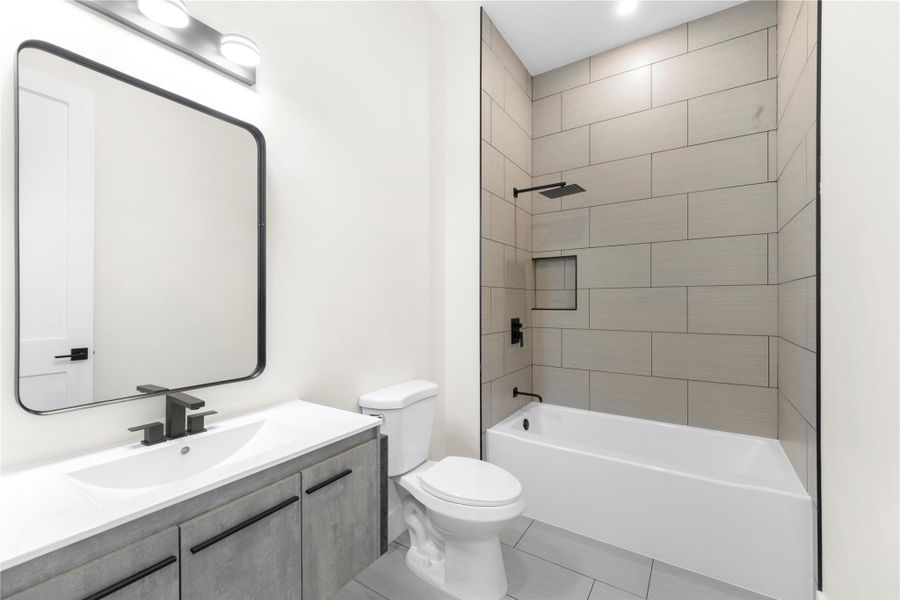Bathroom featuring shower / washtub combination, vanity, and light tile patterned flooring Bathroom featuring shower / washtub combination, vanity, and light tile patterned flooring