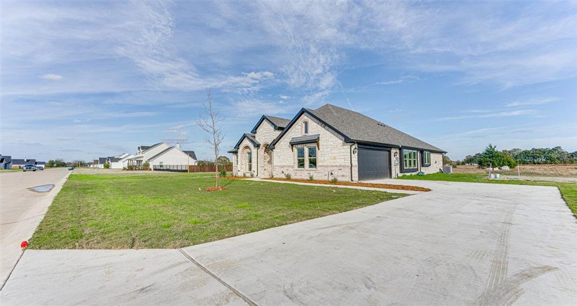 View of front of home featuring a front lawn and a garage