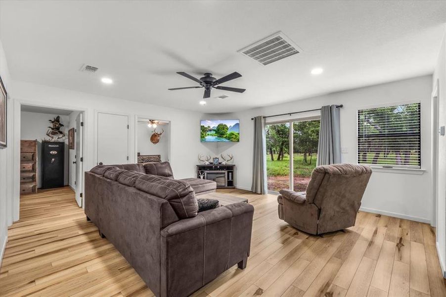 Spacious living area featuring wood-finish flooring, recessed lighting, and a ceiling fan