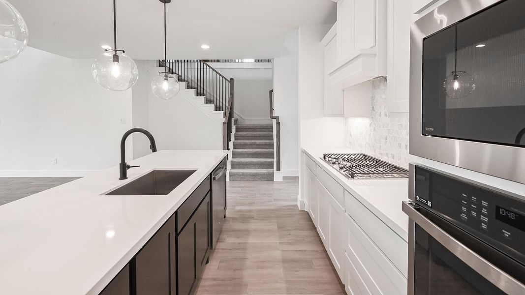 Kitchen featuring light countertops, light wood-type flooring, stainless steel appliances, and a sink