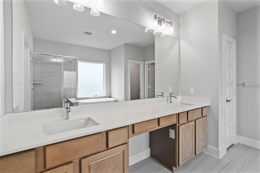 This primary bathroom is definitely move-in ready! Featuring stained cabinets with light countertops, spacious walk-in closet with shelving, high ceilings, custom paint, and sleek modern finishes.