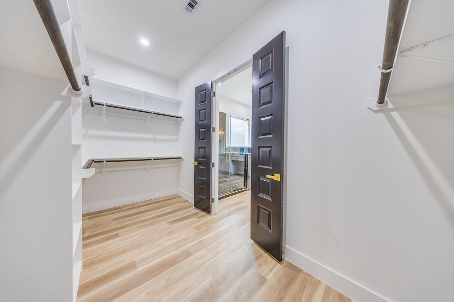 Spacious walk-in closet in the primary bedroom, offering ample storage, organization options, and a luxurious, functional design. Spacious walk-in closet in the primary bedroom, offering ample storage, organization options, and a luxurious, functional design.
