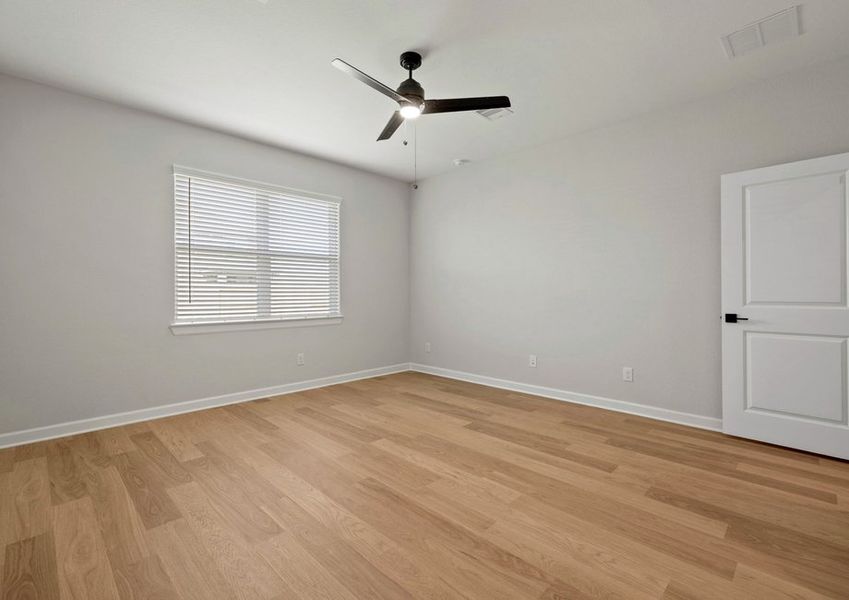 Master bedroom with a large window and ceiling fan light fixture