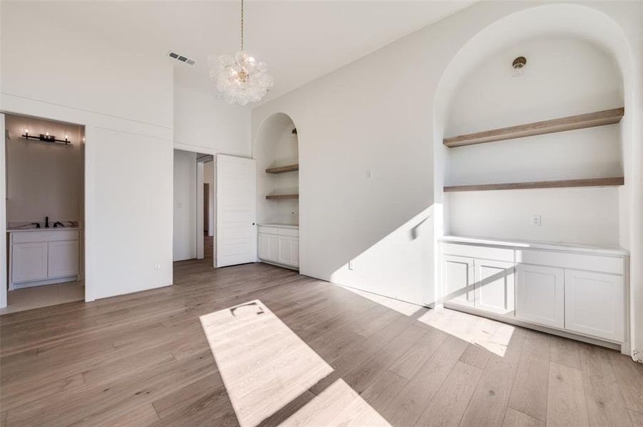 View of secondary bedroom, playroom, media room ,etc. Room has ensuite bathroom. This room features custom built-ins with white oak floating shelves. View of secondary bedroom, playroom, media room ,etc. Room has ensuite bathroom. This room features custom built-ins with white oak floating shelves.